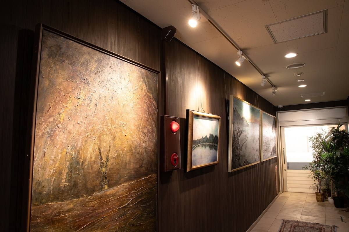 A large oil painting in a dark wood corridor