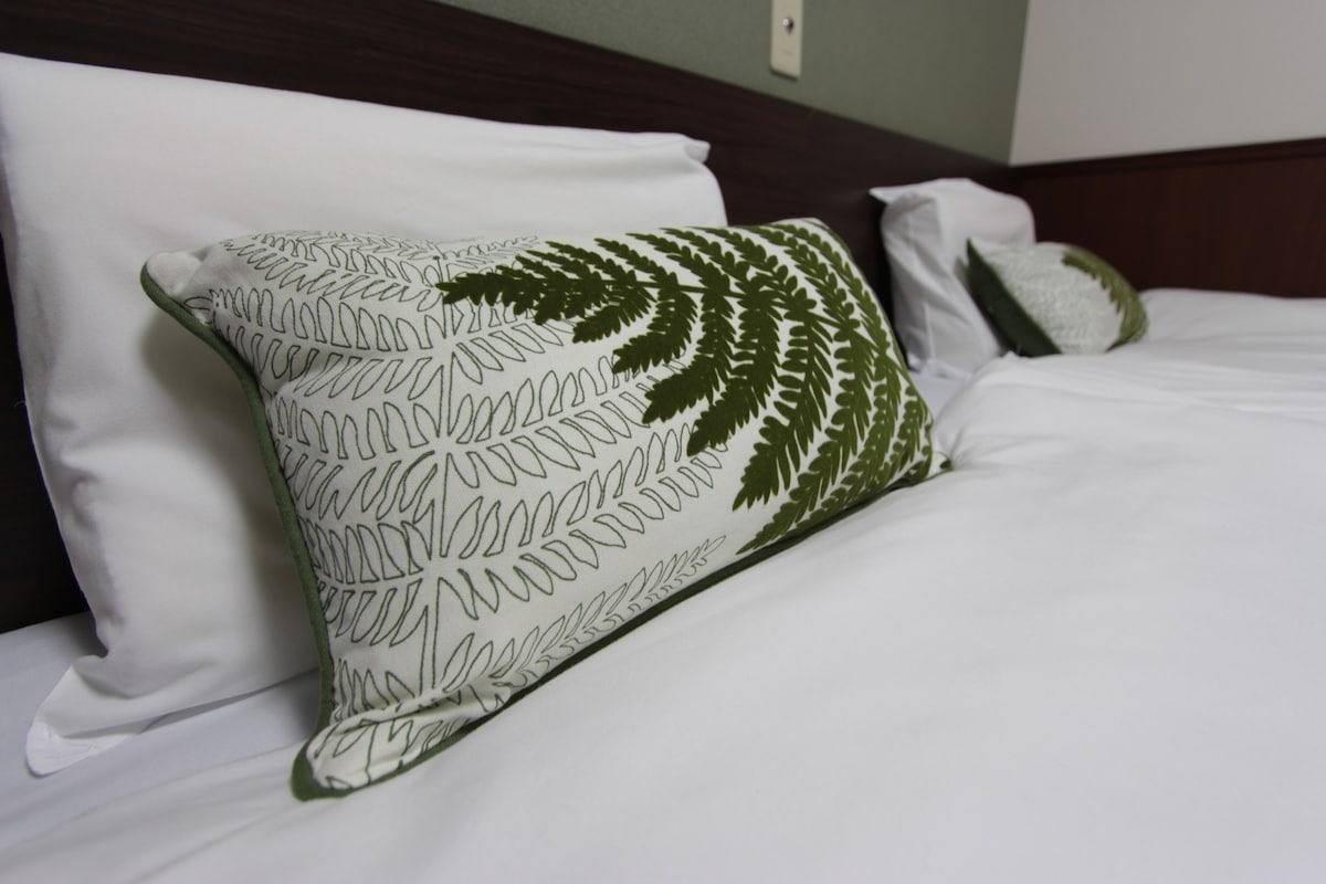 Fern-print cushion on the bed