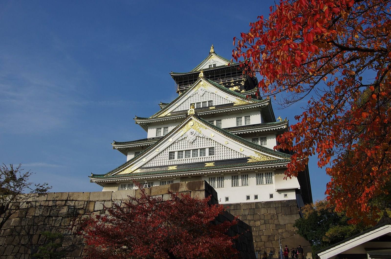Osaka Castle framed by red autumn leaves