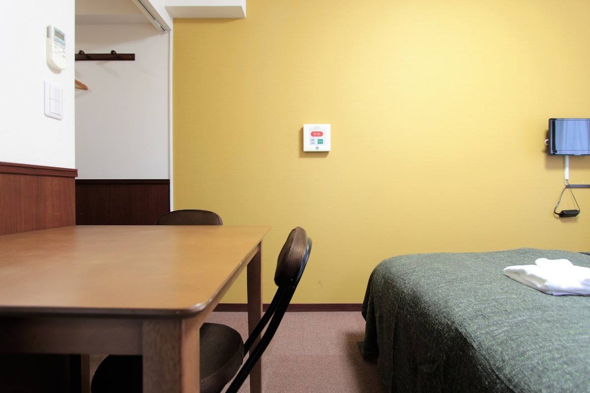 Studio Twin with yellow walls and a desk